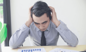 A person in distress looking at two charts.