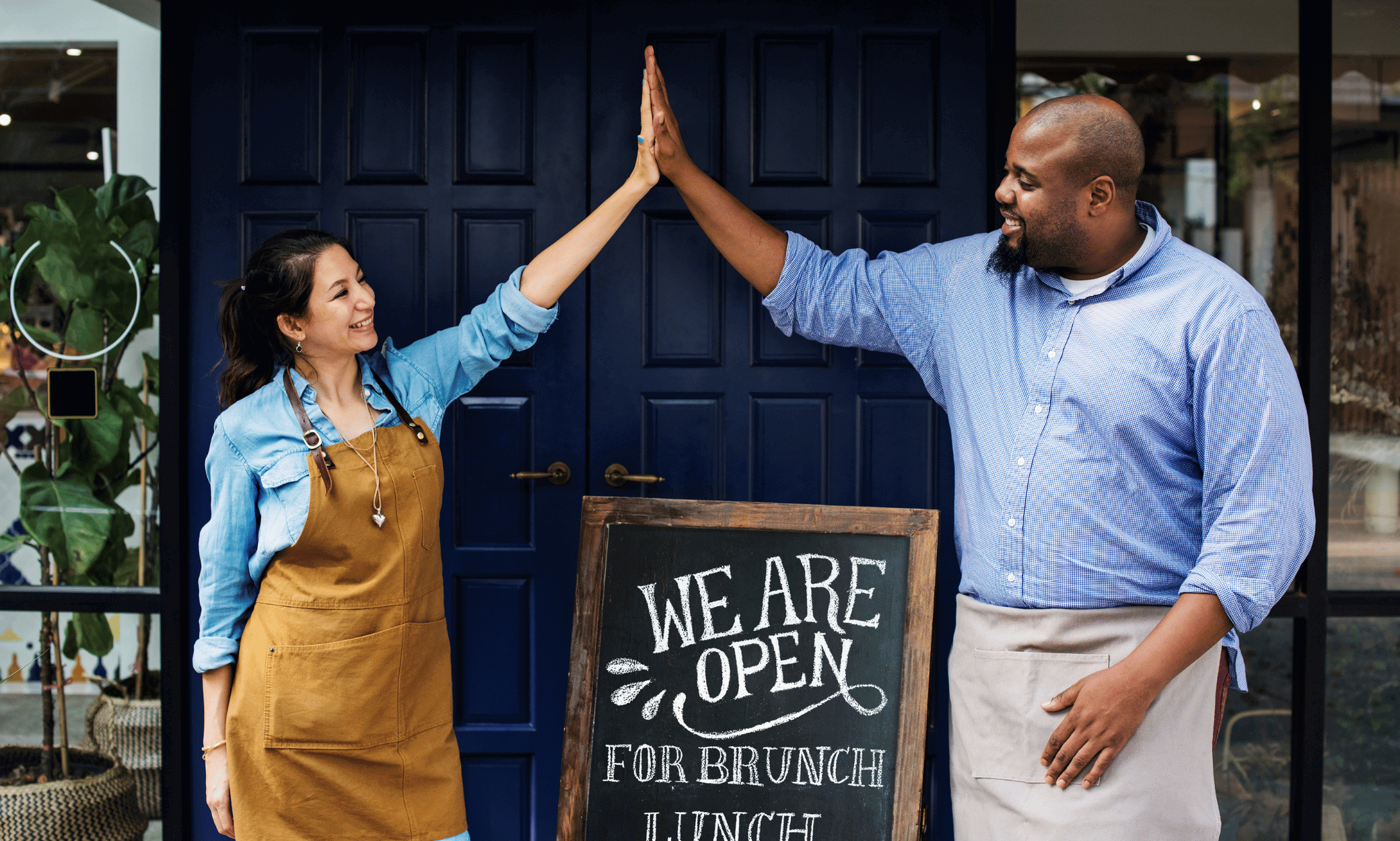Two small business owners high fiving.